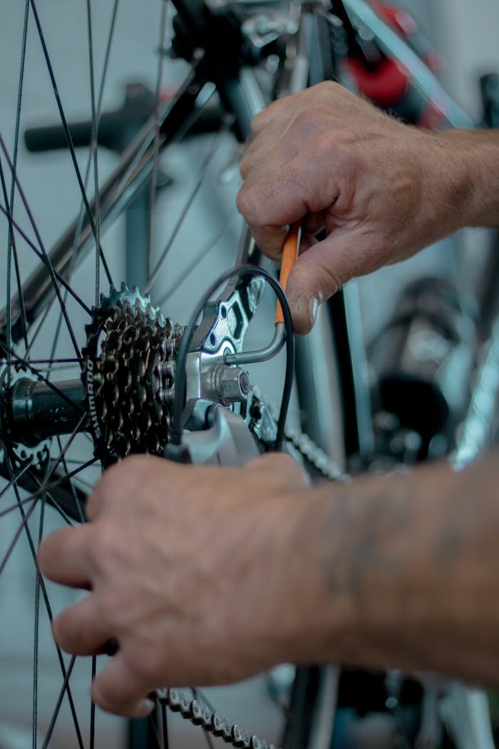 About Detailed image of hands performing maintenance on a bicycle gear using tools.